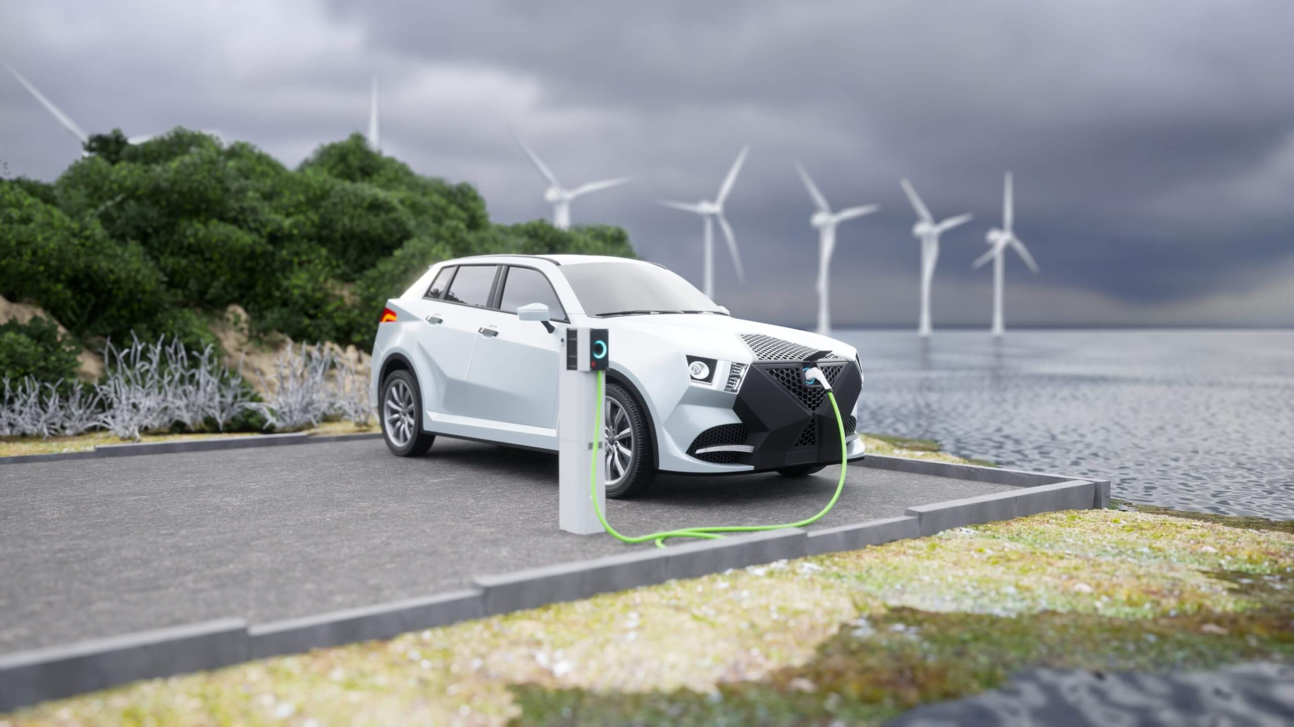 Electric vehicle plugged into a charging station by a body of water with windmills in the background.