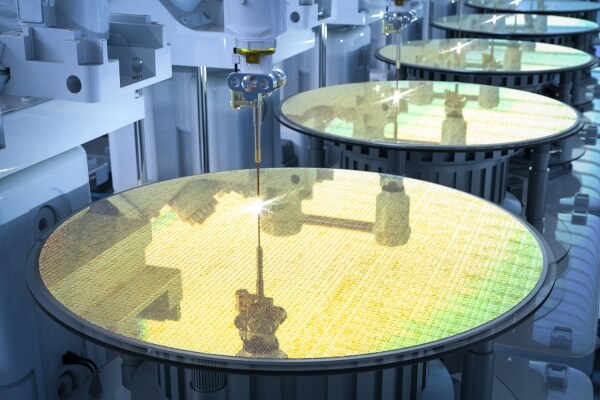 Close-up of silicon wafers undergoing processing in a semiconductor manufacturing facility, with Parylene conformal coating protecting system components.