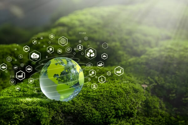 A transparent globe on green moss with digital environmental icons floating around, representing sustainability and ecology.